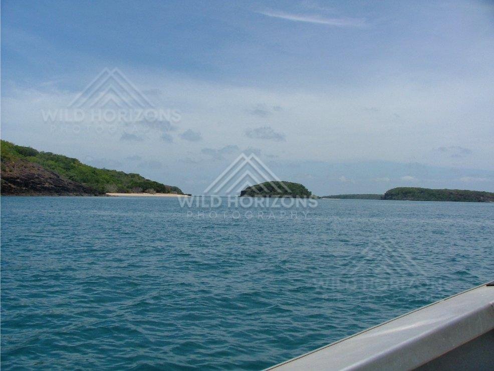 Boat view toward twin islands and sandy shoreline. Seisia, Australia.