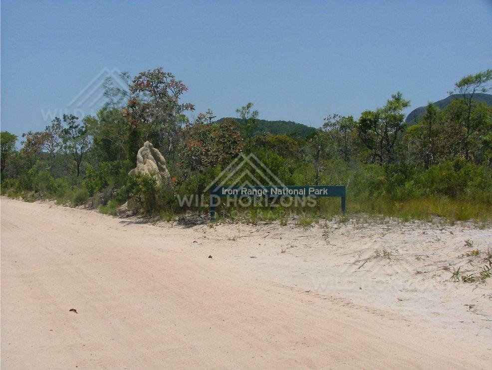 Roadside entry sign for Iron Range National Park beside sandy track. Iron Range National Park, Australia.