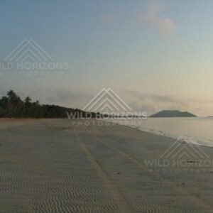Rippled sand patterns across a vast coastal beach. Chili Beach, Australia.