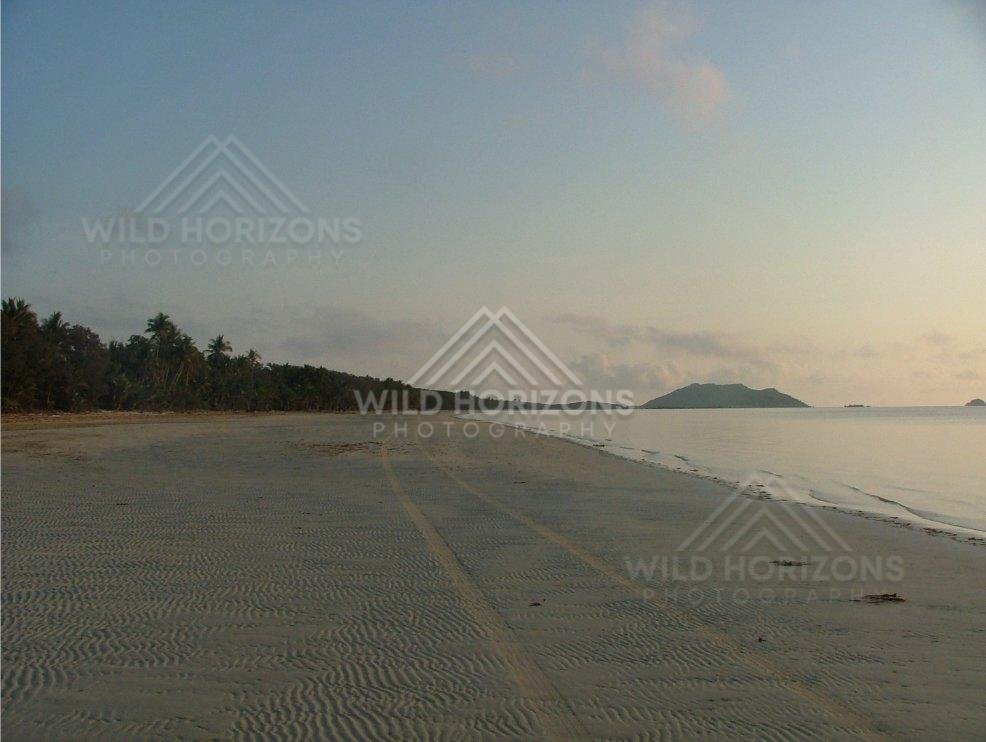 Rippled sand patterns across a vast coastal beach. Chili Beach, Australia.
