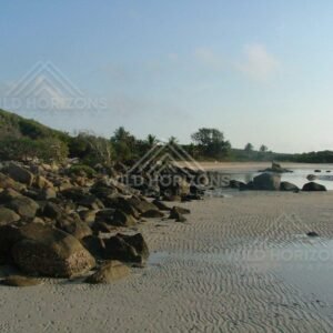Rocky shoreline and sand ripples along a sheltered tropical beach. Chili Beach, Australia.