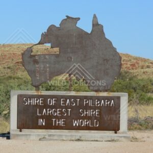 Roadside monument sign shaped as Australia reading “Shire of East Pilbara – Largest Shire in the World”. East Pilbara, Australia.