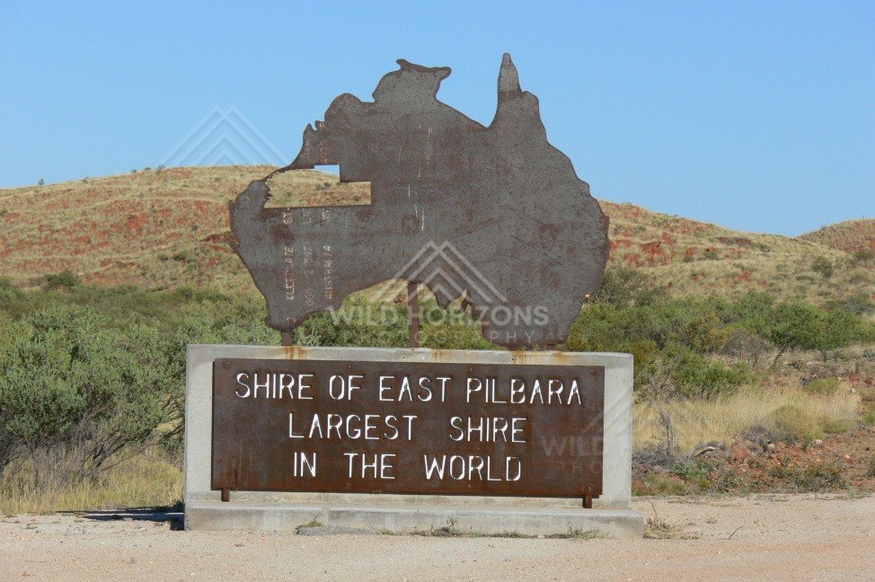 Roadside monument sign shaped as Australia reading “Shire of East Pilbara – Largest Shire in the World”. East Pilbara, Australia.
