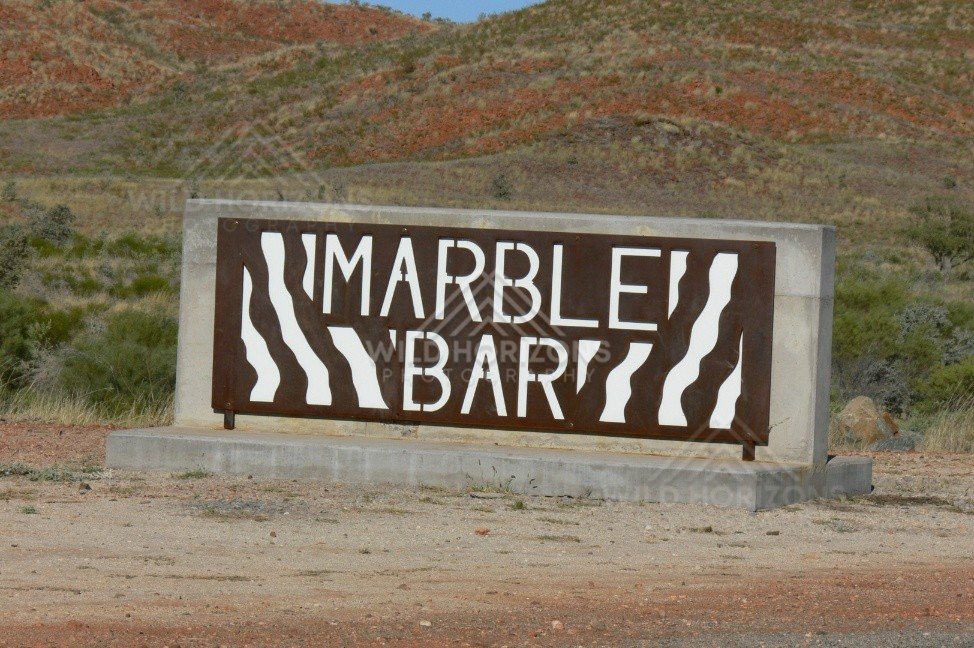 Steel cut-out town sign reading “Marble Bar” beside the highway. Marble Bar, Australia.