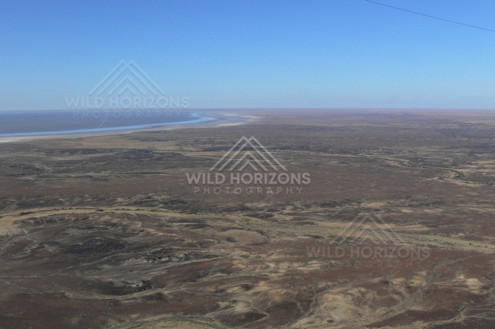 Stony desert country beside distant lake edge. Lake Eyre Basin, Australia.