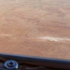 Vehicle crossing remote Channel Country track raising dust. Cooper Creek Region, Australia.