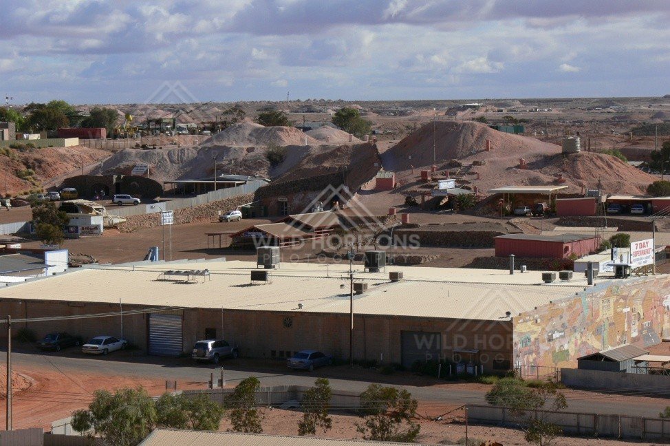 Aerial view across the opal mining town with mullock heaps and low industrial roofs. Coober Pedy, Australia.