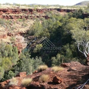 Wide view from the Kings Canyon rim across layered sandstone cliffs and distant desert plains. Watarrka National Park, Australia.