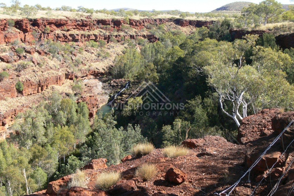 Wide view from the Kings Canyon rim across layered sandstone cliffs and distant desert plains. Watarrka National Park, Australia.