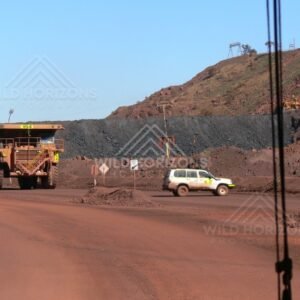Haul truck passing a mine utility vehicle on a red dirt access road. Pilbara, Australia.