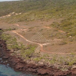 Coastal headland with vehicle tracks across open heath. Narau Beach, Queensland, Australia.