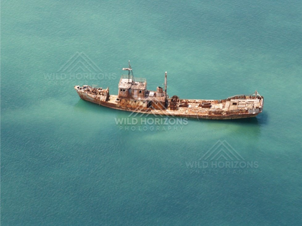 Rusted shipwreck lying offshore. Seisia, Queensland, Australia.
