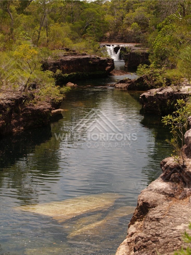 Rock pool with rear waterfall and reflections. Fruitbat Falls, Queensland, Australia.