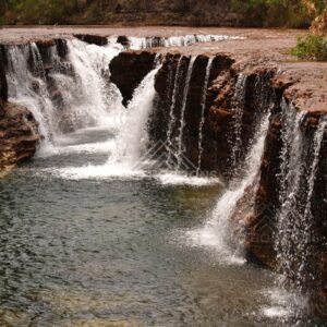 Frontal view of waterfall curtain over sandstone lip. Fruitbat Falls, Queensland, Australia.