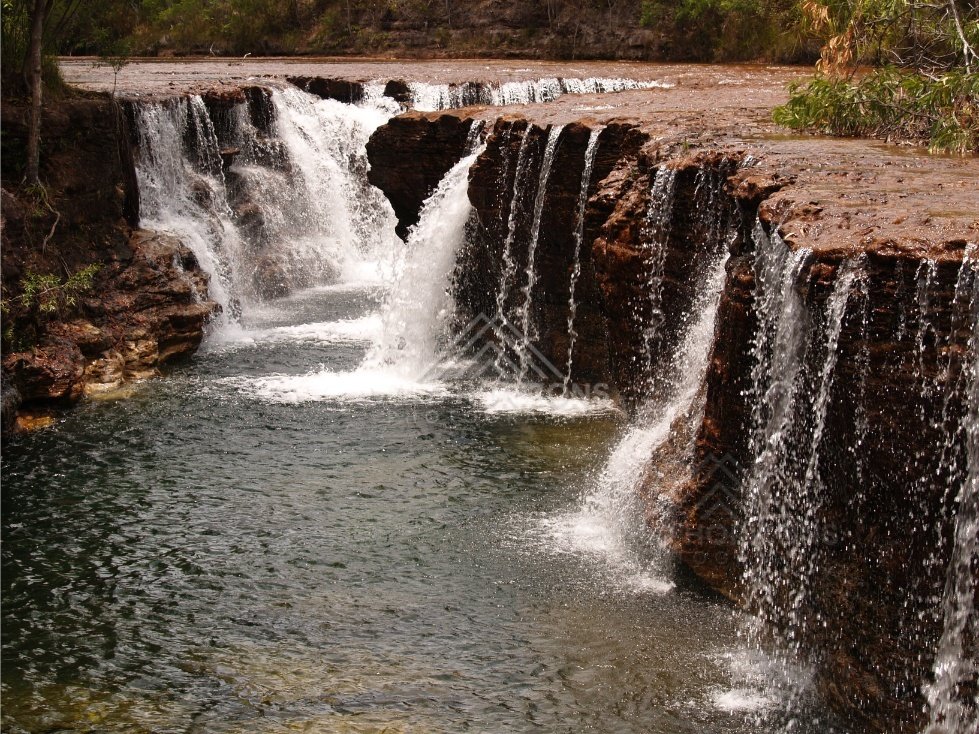 Frontal view of waterfall curtain over sandstone lip. Fruitbat Falls, Queensland, Australia.