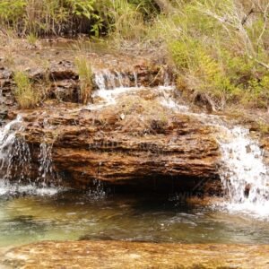 Twin trickle falls over rock shelf. Fruitbat Falls, Queensland, Australia.