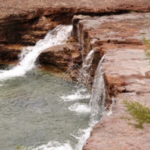 Diagonal view of waterfall and rock ledge. Fruitbat Falls, Queensland, Australia.