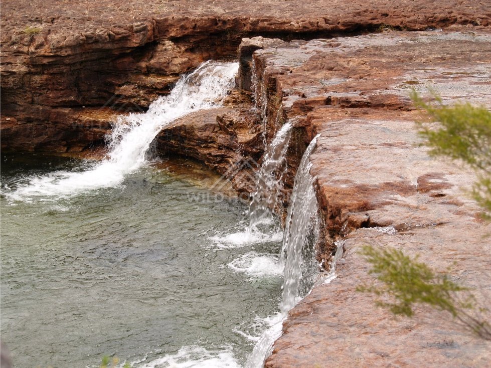 Diagonal view of waterfall and rock ledge. Fruitbat Falls, Queensland, Australia.