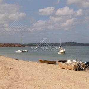 Sandy beach with small boats and anchored yachts offshore. Seisia, Queensland, Australia.