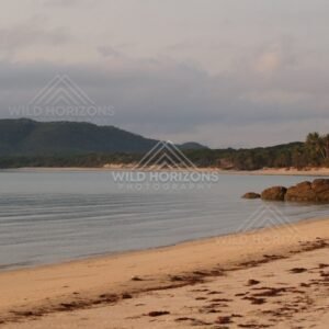 Quiet tropical bay with granite rocks and a sandy beach in soft light. Portland Roads, Australia.