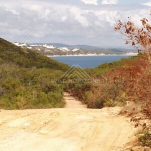 Sandy track descending toward the sea between coastal hills. Elim Beach, Australia.
