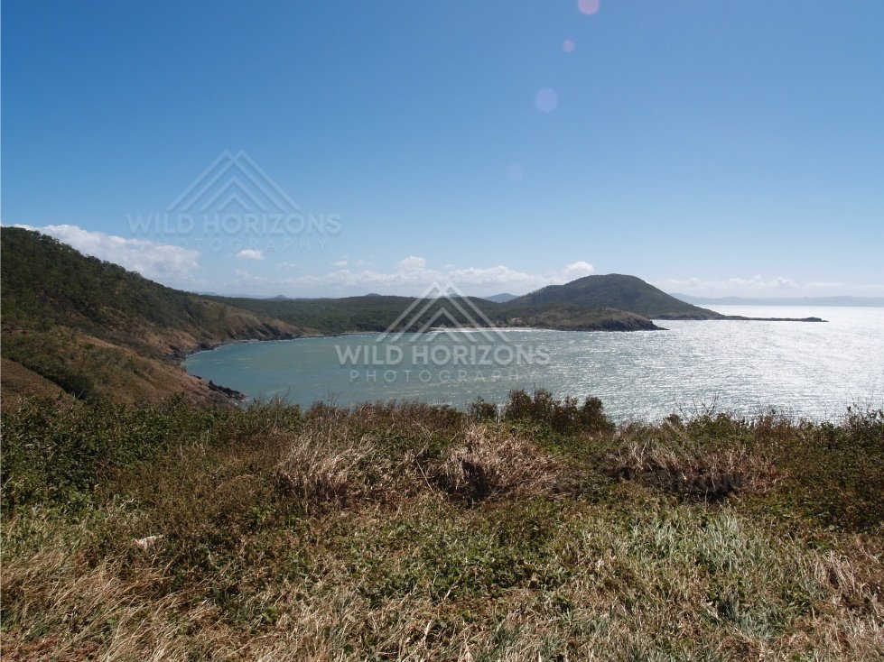 Coastal headlands and bright water seen from a grassy lookout. Cape York, Australia.