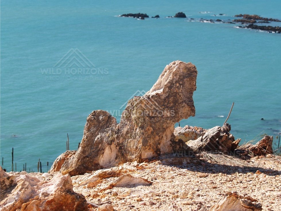 Weathered rock pinnacles above clear blue sea. Cape York Region, Australia.