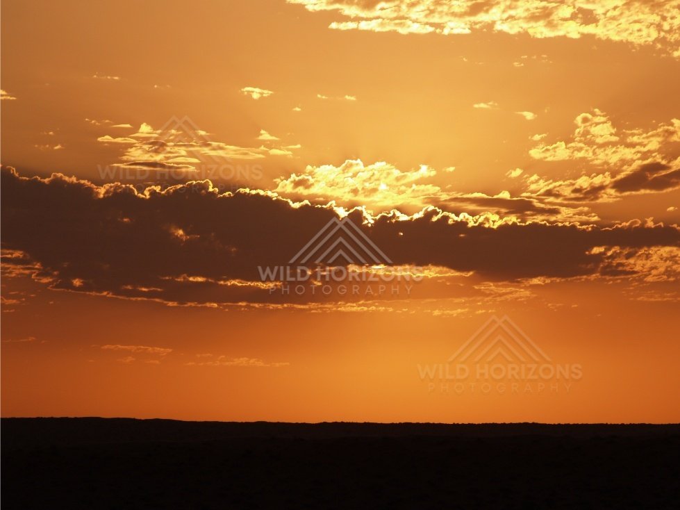 Golden clouds lit by the setting sun. Simpson Desert, Australia.