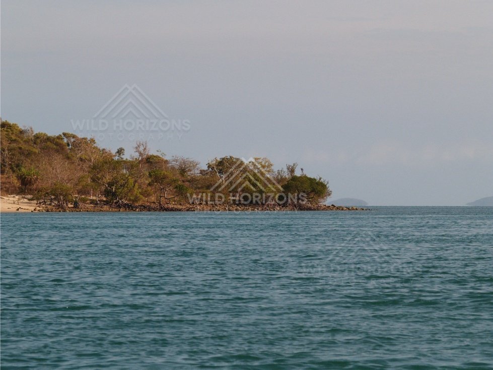 Rocky tropical coastline with open sea under cloudy skies. Cape York, Queensland, Australia.