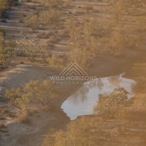 Small desert waterhole reflecting sky. Simpson Desert, Australia.