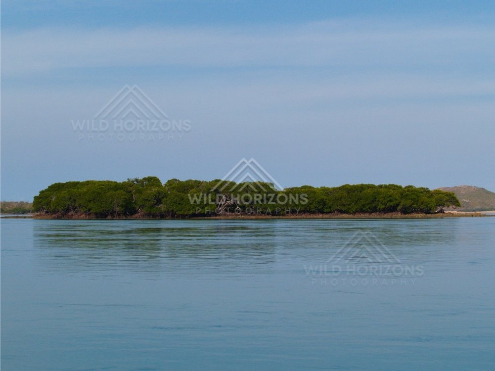 Forested tropical island seen across calm sea. Cape York, Queensland, Australia.