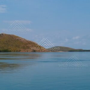 Rounded hill island across a glassy tropical channel. Cape York, Queensland, Australia.