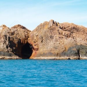 Orange coastal cliffs with a sea cave entrance. Cape York, Queensland, Australia.