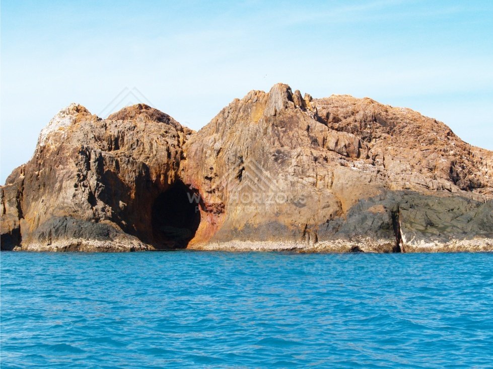 Orange coastal cliffs with a sea cave entrance. Cape York, Queensland, Australia.