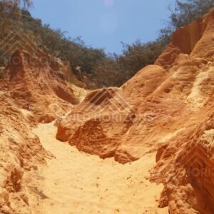 Sandy track between coloured sandstone cliffs. Rainbow Beach, Australia.