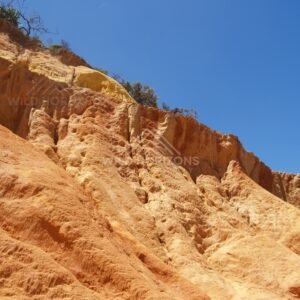 Broad eroded cliff of ochre sandstone. Rainbow Beach, Australia.