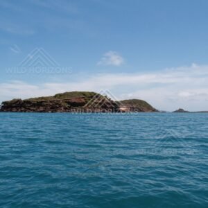 Low rocky island viewed from open turquoise water. Cape York, Queensland, Australia.