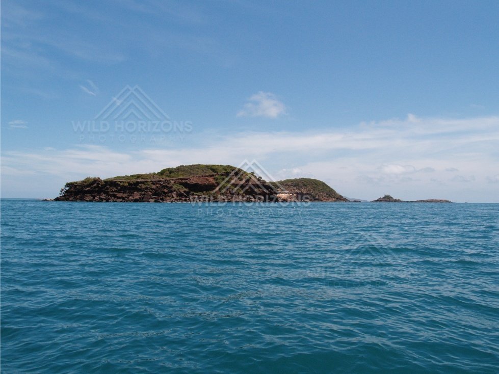 Low rocky island viewed from open turquoise water. Cape York, Queensland, Australia.