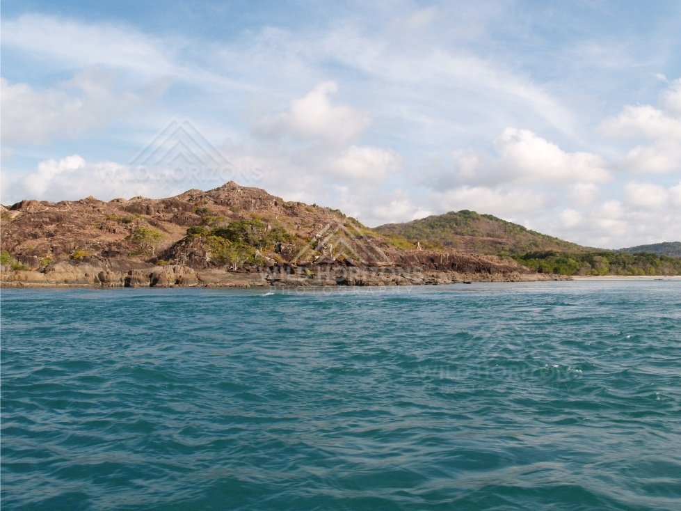 Rugged coastal hills seen across choppy water. Cape York, Queensland, Australia.