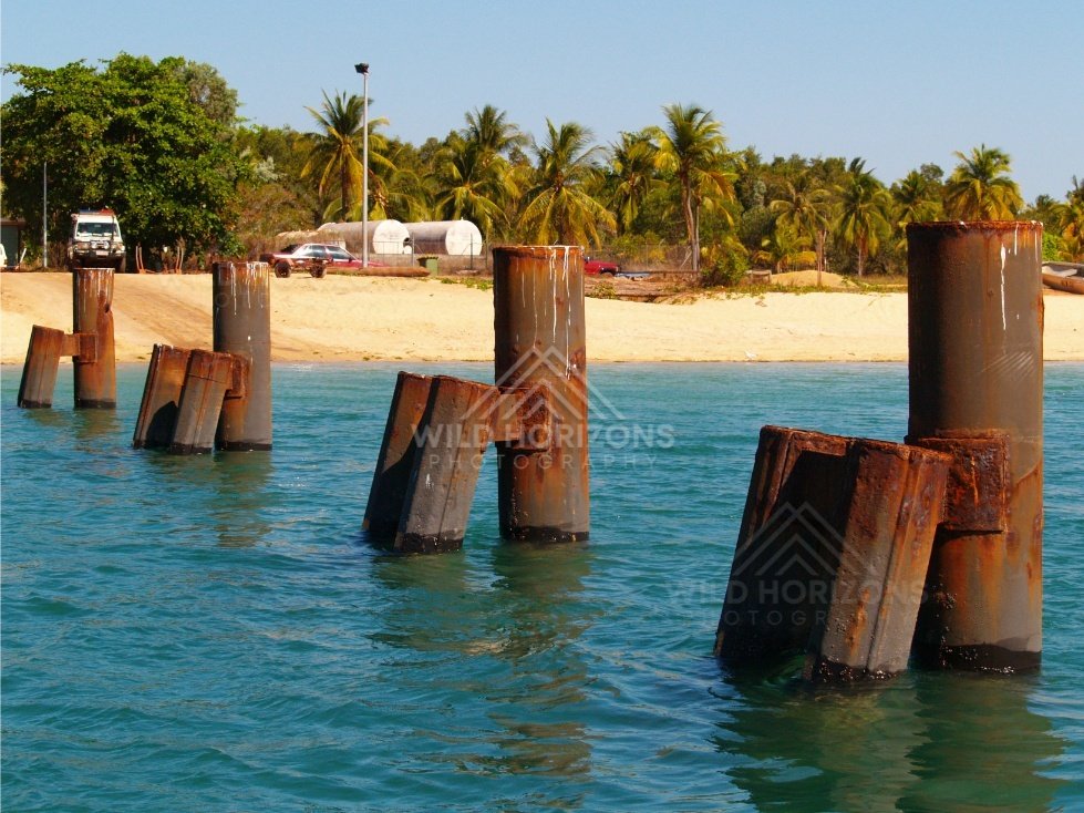 Rusted wharf pylons and beach structures. Seisia, Queensland, Australia.