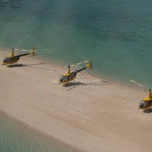 Three yellow helicopters parked on a sandy spit. Thursday Island, Queensland, Australia.