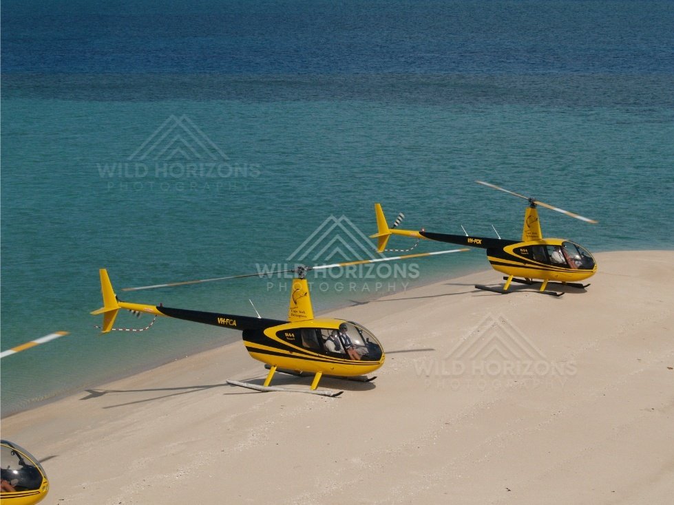 Helicopters on beach beside clear tropical water. Thursday Island, Queensland, Australia.