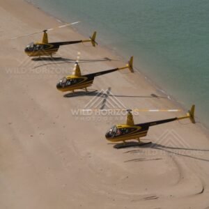 Two helicopters resting on sand near the sea. Thursday Island, Queensland, Australia.