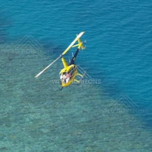Single helicopter in flight over shallow sea. Thursday Island, Queensland, Australia.