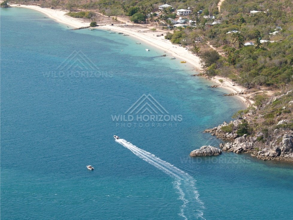 Curving beach and forested headland from the air. Thursday Island, Queensland, Australia.