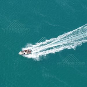 Small boat leaving wake across blue water. Thursday Island, Queensland, Australia.